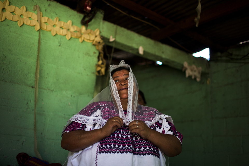 María Alberta Choc, enseña un traje ceremonial usado por las mujeres durante las procesiones de la cofradía local.