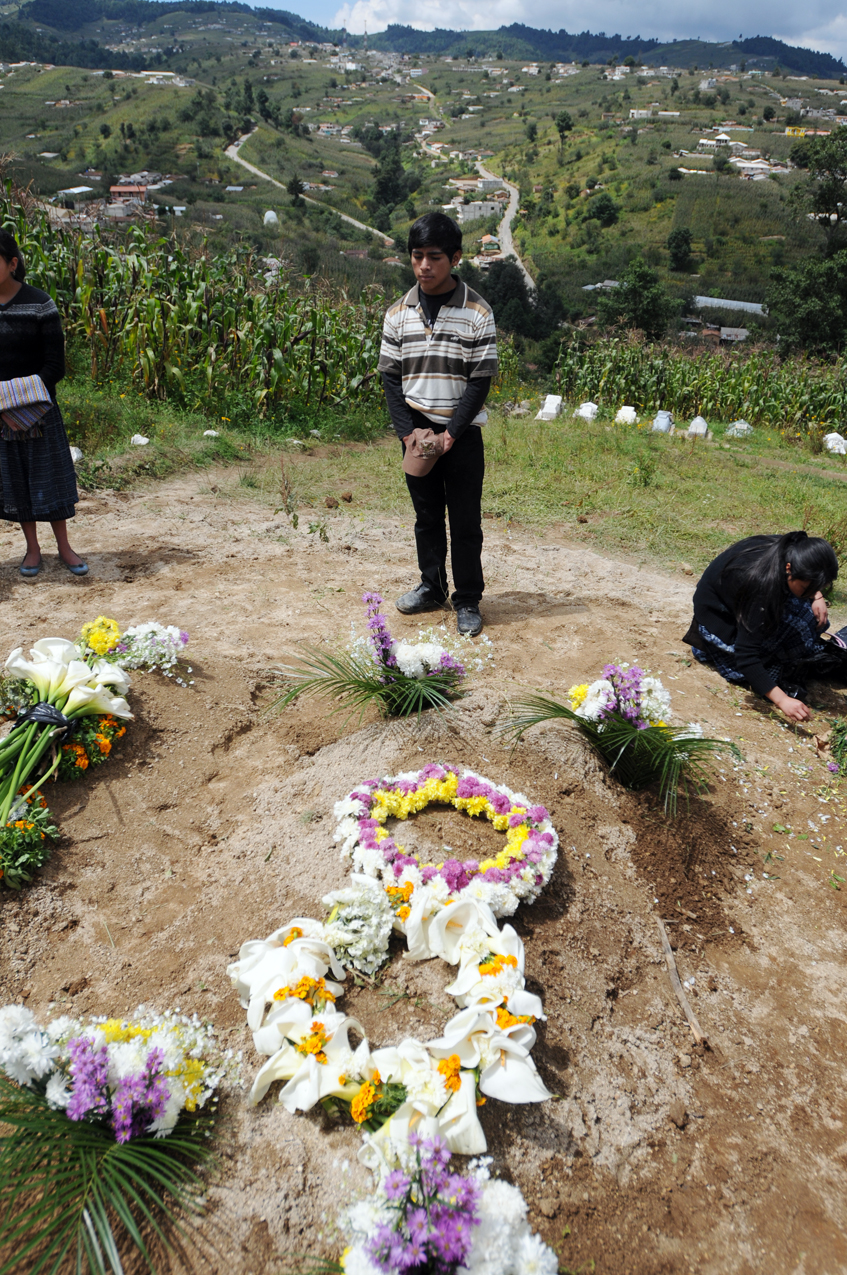 Santos Caxaj, estudiante normalista, visita la tumba de su padre.