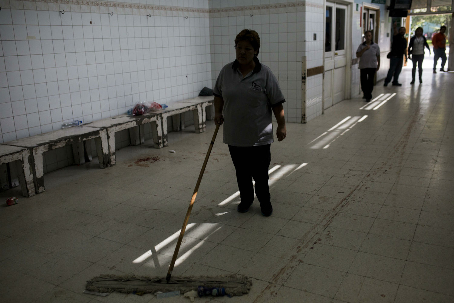 Una mujer limpia un pasillo del Hospital Roosevelt después de la masacre.